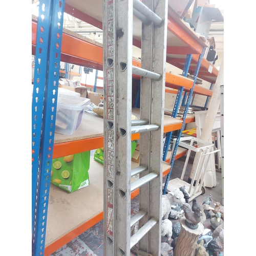 1365 - A double extendable eighteen rung aluminium work ladder