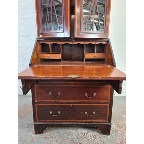 1004A - An Edwardian inlaid mahogany bureau bookcase with shell and fan inlay, upper swan neck pediment, two... 