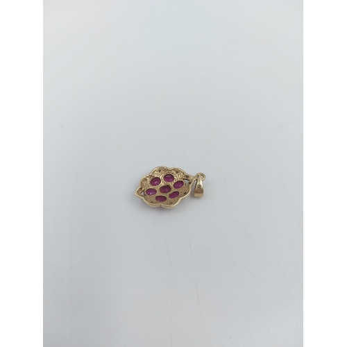 66 - A stamped 9ct gold necklace pendant with seven inset rubies