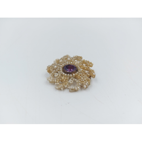 69 - A Georgian Mother of Pearl brooch with central amethyst and unmarked gold coloured clasp