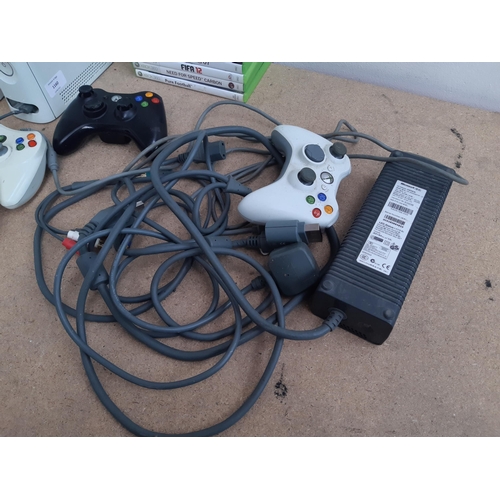 1160 - A collection of Xbox 360 items to include two consoles, controllers, game discs ad power adaptor