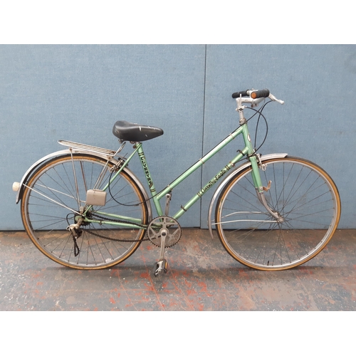 1213 - A vintage green Coventry Eagle lady's town bike with rear carrier, sprung saddle and five speed Altu... 