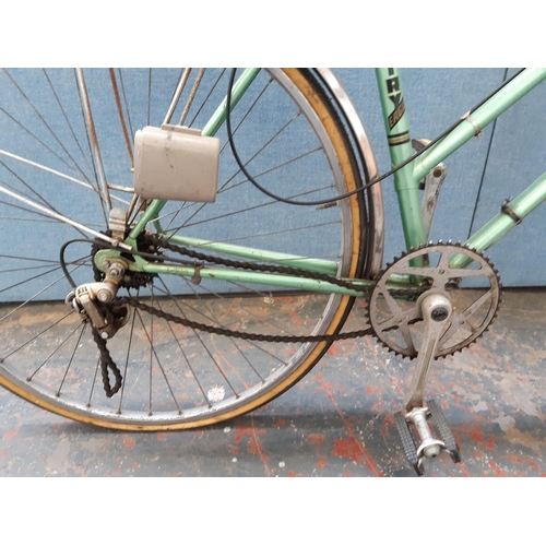 1213 - A vintage green Coventry Eagle lady's town bike with rear carrier, sprung saddle and five speed Altu... 