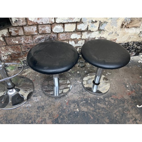 1231A - Five contemporary stools, four black leatherette low stools and one black plastic kitchen bar stool