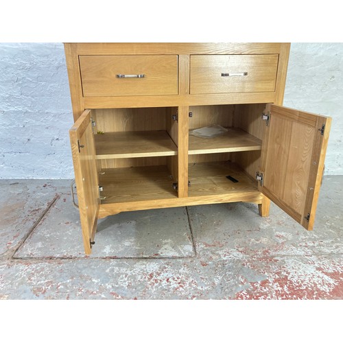 1056A - A modern oak sideboard with two drawers and two lower cupboard doors - approx. 83cm high x 94cm wide... 