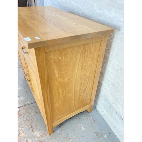 1056A - A modern oak sideboard with two drawers and two lower cupboard doors - approx. 83cm high x 94cm wide... 