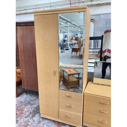 1039A - A mid/late 20th century oak effect three piece bedroom suite comprising double wardrobe - approx. 18... 