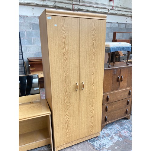 1039A - A mid/late 20th century oak effect three piece bedroom suite comprising double wardrobe - approx. 18... 