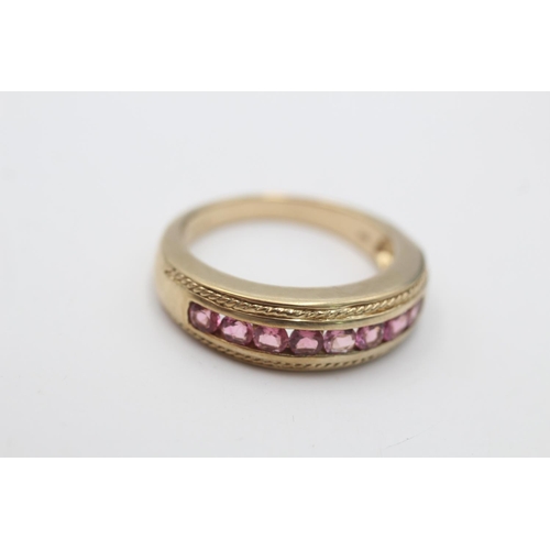 57 - A hallmarked Birmingham 9ct gold pink tourmaline channel set half eternity ring, size T - approx. gr... 