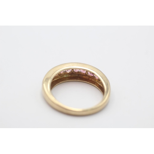 57 - A hallmarked Birmingham 9ct gold pink tourmaline channel set half eternity ring, size T - approx. gr... 