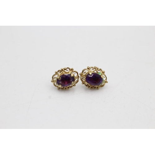 68 - Two pairs of 9ct gold stud earrings, one amethyst and one purple gemstone - approx. gross weight 2.1... 