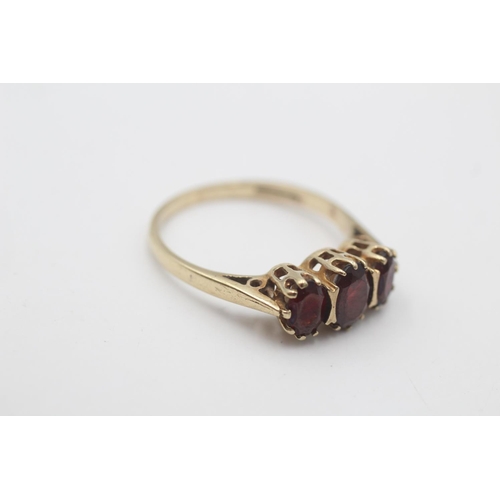 91 - A 9ct gold garnet three stone gypsy setting ring, size R½ - approx. gross weight 2.8 grams