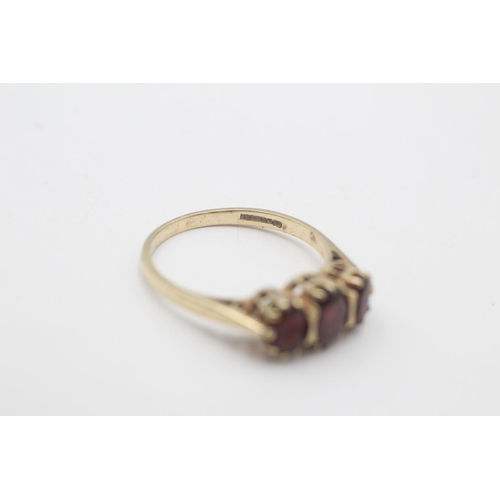 91 - A 9ct gold garnet three stone gypsy setting ring, size R½ - approx. gross weight 2.8 grams