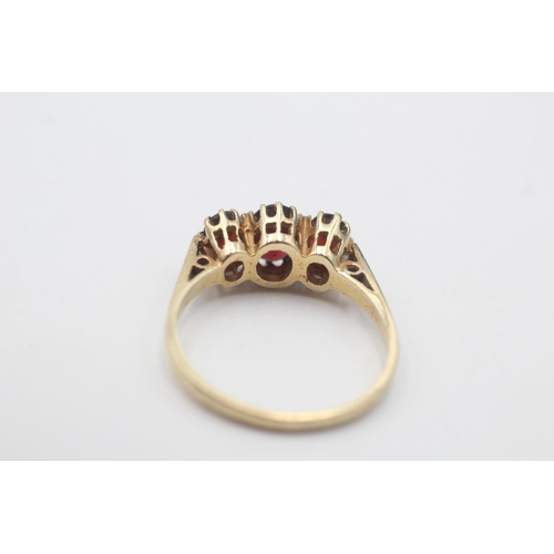 91 - A 9ct gold garnet three stone gypsy setting ring, size R½ - approx. gross weight 2.8 grams