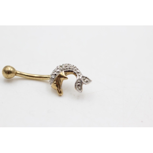 29 - A 9ct two tone gold diamond dolphin belly bar - approx. gross weight 1.4 grams