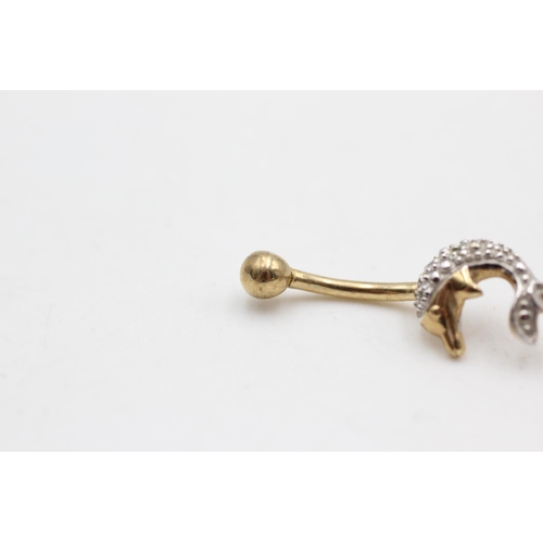 29 - A 9ct two tone gold diamond dolphin belly bar - approx. gross weight 1.4 grams