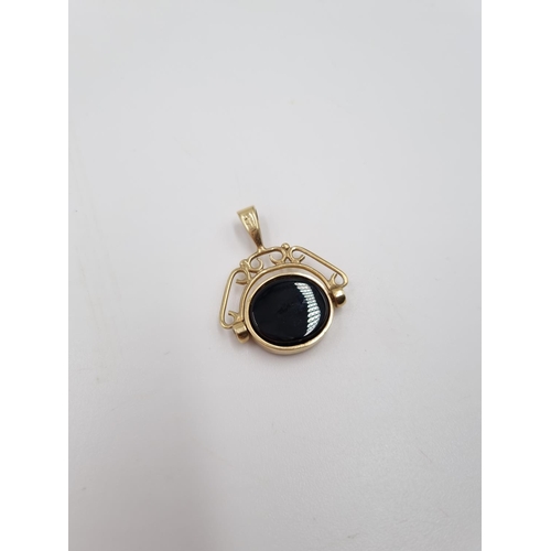 1 - Two 9ct gold pendants, one onyx and paste swivel pendant and one emergency money - approx. gross 7.6... 