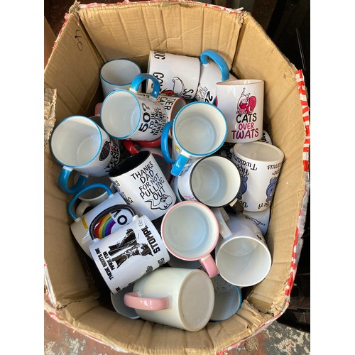 1610 - Two boxes containing assorted novelty mugs