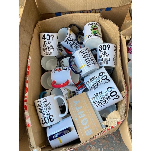 1612 - Two boxes containing assorted novelty mugs