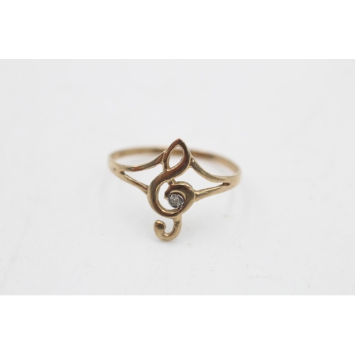 76 - A 9ct gold diamond set treble clef dress ring, size L½ - approx. gross weight 0.7 grams