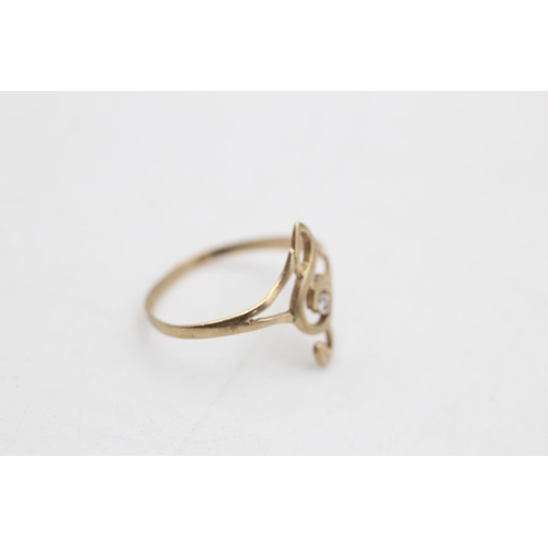 76 - A 9ct gold diamond set treble clef dress ring, size L½ - approx. gross weight 0.7 grams