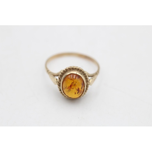 79 - A 9ct gold amber solitaire dress ring, size M½ - approx. gross weight 1.7 grams