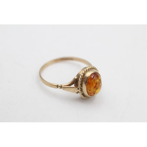 79 - A 9ct gold amber solitaire dress ring, size M½ - approx. gross weight 1.7 grams