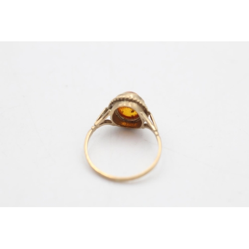 79 - A 9ct gold amber solitaire dress ring, size M½ - approx. gross weight 1.7 grams