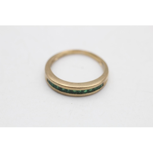 97 - A 9ct gold emerald channel set half eternity ring, size P - approx. gross weight 2.6 grams