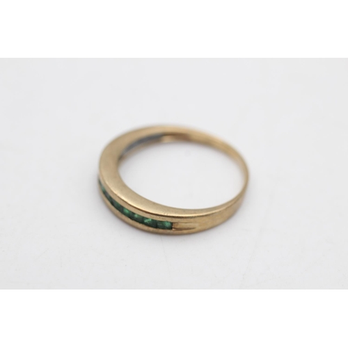 97 - A 9ct gold emerald channel set half eternity ring, size P - approx. gross weight 2.6 grams