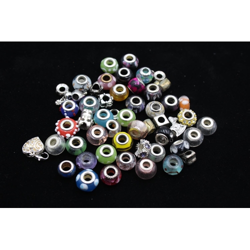 104 - A large collection of bracelet charms, some stamped .925 silver