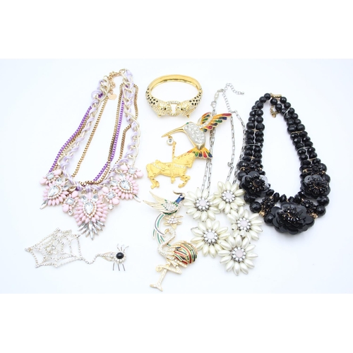 107 - Nine pieces of statement costume jewellery to include necklaces, brooches etc.