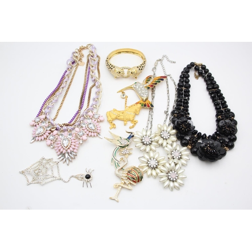 107 - Nine pieces of statement costume jewellery to include necklaces, brooches etc.