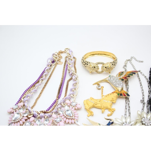 107 - Nine pieces of statement costume jewellery to include necklaces, brooches etc.