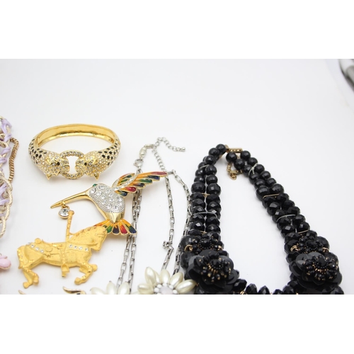 107 - Nine pieces of statement costume jewellery to include necklaces, brooches etc.