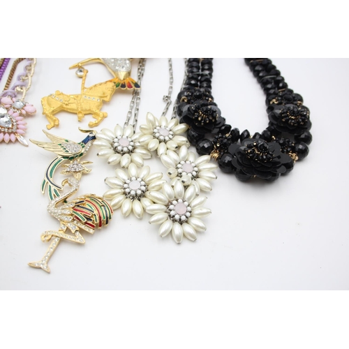 107 - Nine pieces of statement costume jewellery to include necklaces, brooches etc.
