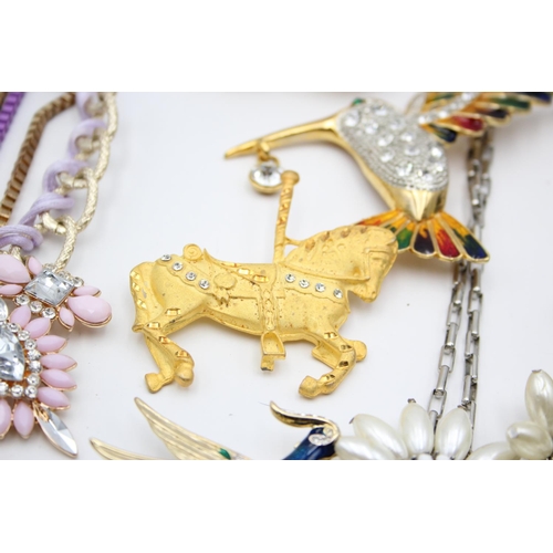 107 - Nine pieces of statement costume jewellery to include necklaces, brooches etc.