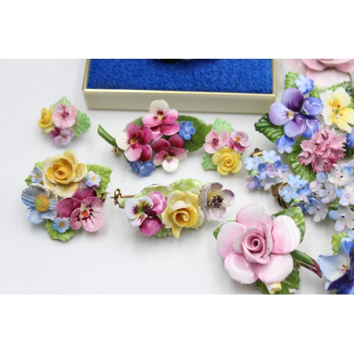 113 - Twenty five pieces of porcelain jewellery to include brooches, pins etc.