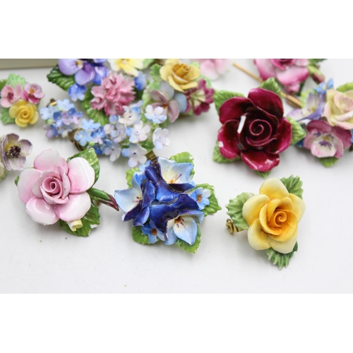 113 - Twenty five pieces of porcelain jewellery to include brooches, pins etc.