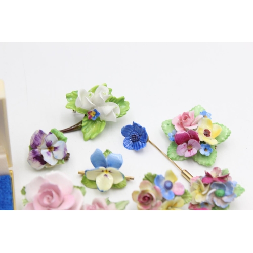 113 - Twenty five pieces of porcelain jewellery to include brooches, pins etc.