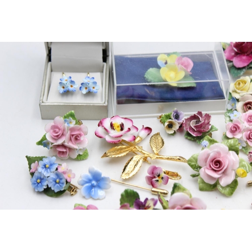 114 - Twenty five pieces of porcelain jewellery to include brooches, pins etc.