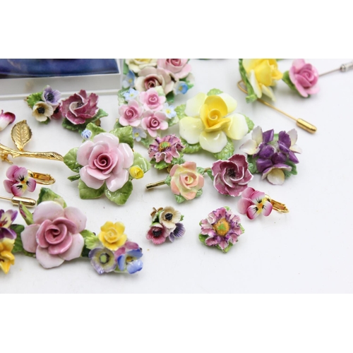 114 - Twenty five pieces of porcelain jewellery to include brooches, pins etc.