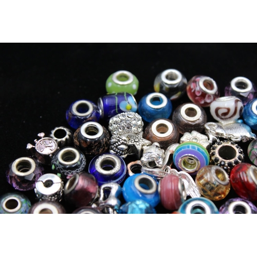 115 - A large collection of bracelet charms, some stamped .925 silver