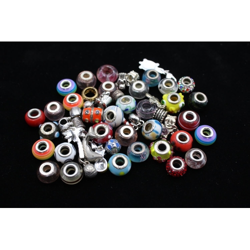 116 - A large collection of bracelet charms, some stamped .925 silver