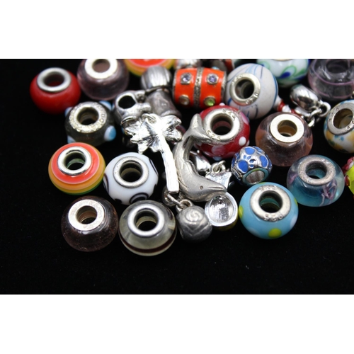 116 - A large collection of bracelet charms, some stamped .925 silver