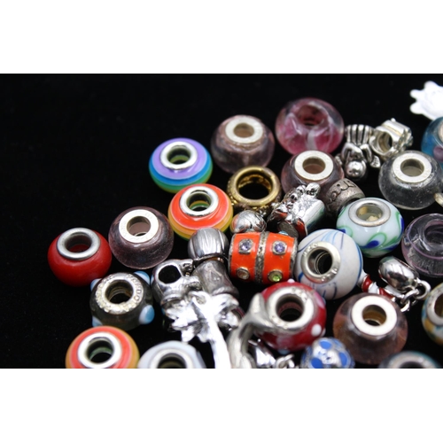 116 - A large collection of bracelet charms, some stamped .925 silver
