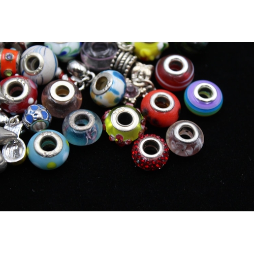 116 - A large collection of bracelet charms, some stamped .925 silver