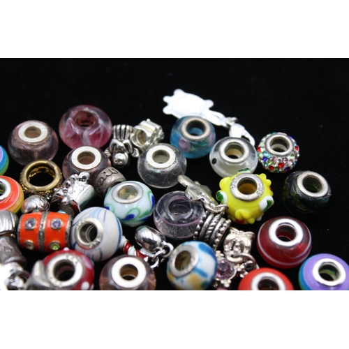 116 - A large collection of bracelet charms, some stamped .925 silver