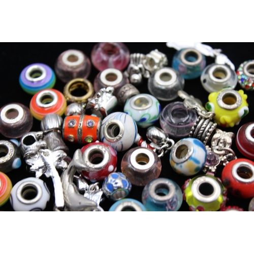 116 - A large collection of bracelet charms, some stamped .925 silver