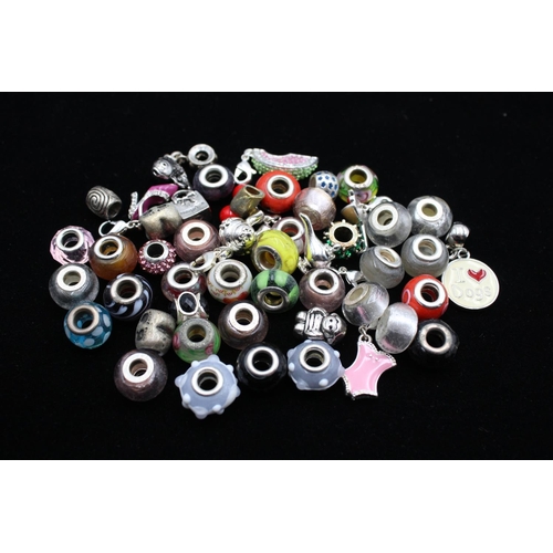 117 - A large collection of bracelet charms, some stamped .925 silver